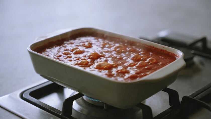 Casserole de sauce tomate bouillante sur cuisiniere