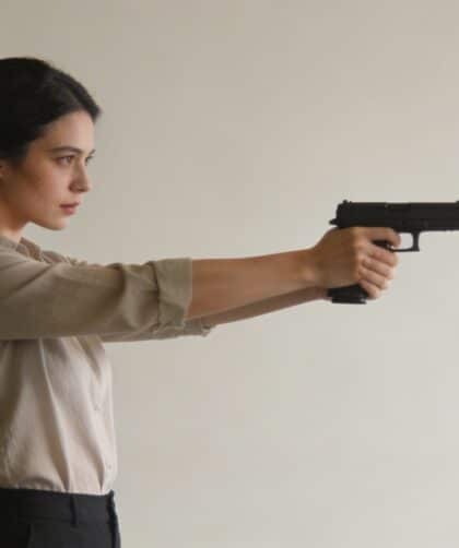 Femme debout visant une cible avec pistolet