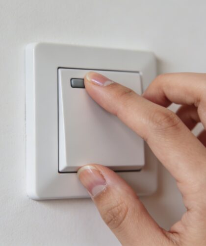 Gros plan sur main ajustant un thermostat mural
