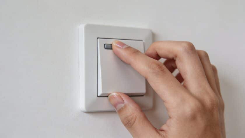 Gros plan sur main ajustant un thermostat mural
