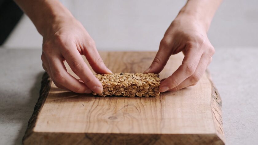 Mains façonnant barres de cereales maison sur planche