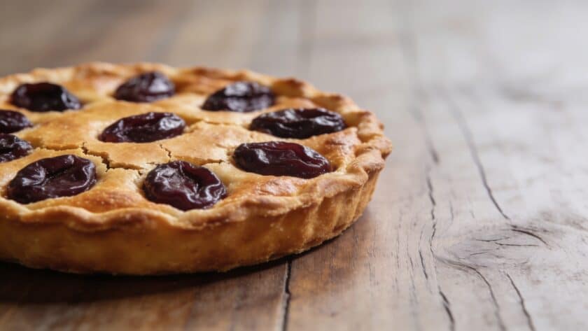 Tarte aux prunes doree sur table en bois