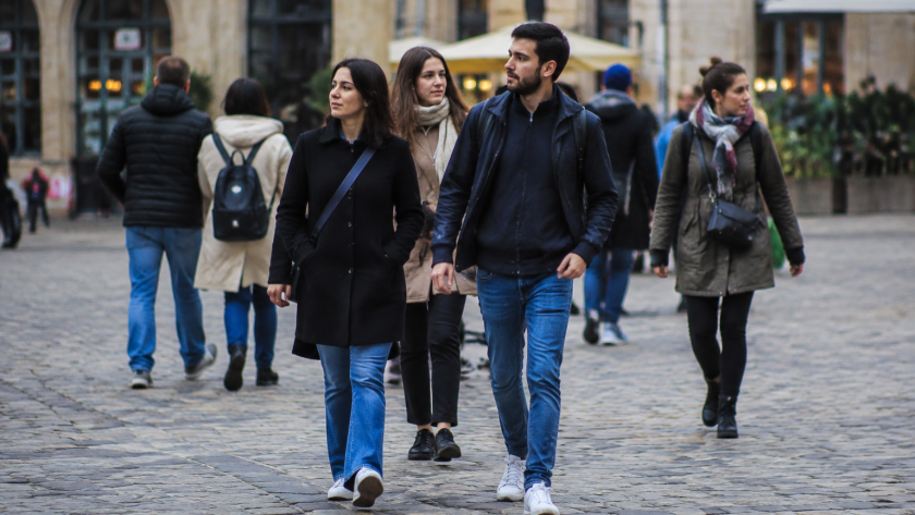 Groupe de passants marchant sur une place pavee