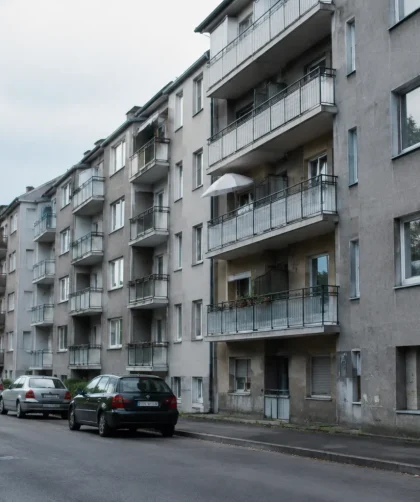 Immeubles gris aux balcons alignés au bord d'une route
