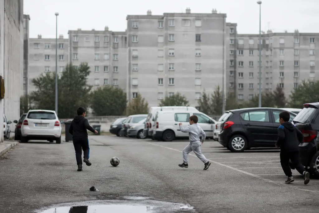 Grands immeubles gris et enfants jouant sur un parking